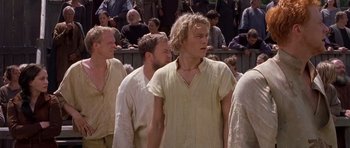 Movie still from “A Knight's Tale” (2001), directed by Brian Helgeland – A group of men standing next to each other in a crowd; Medium shot, Low angle