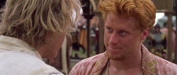 Movie still from “A Knight's Tale” (2001), directed by Brian Helgeland – A man with red hair and blue eyes talking to another man; Close Up shot, Over the shoulder angle
