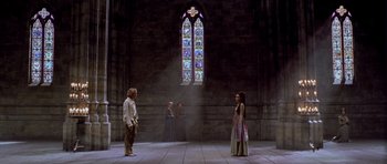 Movie still from “A Knight's Tale” (2001), directed by Brian Helgeland – A group of people standing in front of a stained glass window; Wide shot, High angle