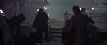 Movie still from “A Knight's Tale” (2001), directed by Brian Helgeland – A group of people standing on steps in the dark; Wide shot, High angle