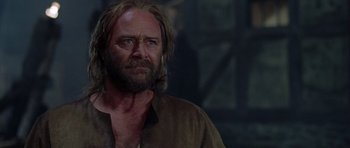 Movie still from “A Knight's Tale” (2001), directed by Brian Helgeland – A man with long hair and a beard looking to his left; Close Up shot, Over the shoulder angle