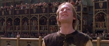 Movie still from “A Knight's Tale” (2001), directed by Brian Helgeland – A man standing in front of a crowd of people; Close Up shot, Low angle
