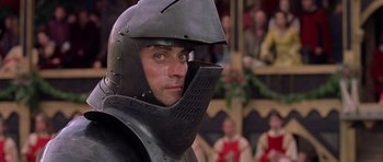Movie still from “A Knight's Tale” (2001), directed by Brian Helgeland – A man in a suit of a medieval knight; Close Up shot, Over the shoulder angle