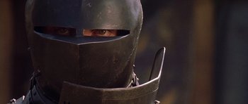 Movie still from “A Knight's Tale” (2001), directed by Brian Helgeland – A person wearing a metal helmet with a sword in it; Close Up shot, High angle
