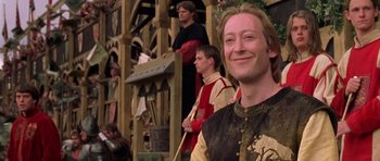 Movie still from “A Knight's Tale” (2001), directed by Brian Helgeland – A man in medieval garb smiles for the camera; Close Up shot, Low angle