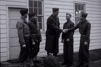 Movie still from “A League of Their Own” (1992), directed by Penny Marshall – A black and white photo of a group of men shaking hands; Wide shot, Low angle