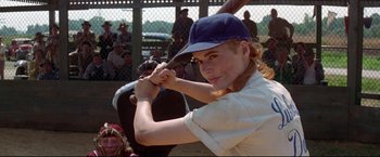 Movie still from “A League of Their Own” (1992), directed by Penny Marshall – A woman in a baseball uniform holding a baseball bat; Medium shot, Low angle