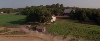 Movie still from “A League of Their Own” (1992), directed by Penny Marshall – An aerial view of a dirt field with a house and a barn; Extreme Wide shot, High angle