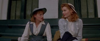 Movie still from “A League of Their Own” (1992), directed by Penny Marshall – A couple of women sitting next to each other on a bench; Medium shot, Over the shoulder angle