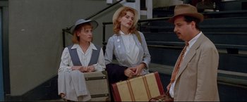 Movie still from “A League of Their Own” (1992), directed by Penny Marshall – A group of women sitting next to each other holding suitcases; Medium shot, Low angle