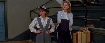 Movie still from “A League of Their Own” (1992), directed by Penny Marshall – Two young women standing next to each other on stairs; Medium shot, Low angle