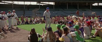 Movie still from “A League of Their Own” (1992), directed by Penny Marshall – A baseball player standing in front of a group of people; Wide shot, Over the shoulder angle