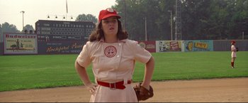 Movie still from “A League of Their Own” (1992), directed by Penny Marshall – A woman in a baseball uniform holding a baseball mitt; Medium shot, Low angle