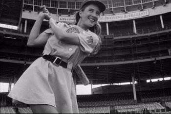 Movie still from “A League of Their Own” (1992), directed by Penny Marshall – A woman in a baseball uniform holding a baseball bat; Medium shot, Low angle