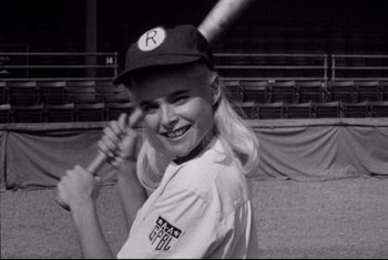 Movie still from “A League of Their Own” (1992), directed by Penny Marshall – A young woman holding a baseball bat on a baseball field; Close Up shot, Low angle
