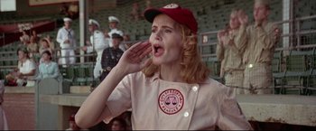Movie still from “A League of Their Own” (1992), directed by Penny Marshall – A woman in a baseball uniform blows a kiss to the crowd; Medium shot, Low angle