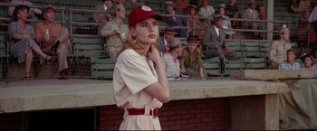 Movie still from “A League of Their Own” (1992), directed by Penny Marshall – A woman in a baseball uniform stands in front of a group of people; Medium shot, Low angle