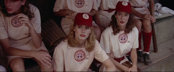 Movie still from “A League of Their Own” (1992), directed by Penny Marshall – A group of women in baseball uniforms sitting next to each other; Close Up shot, Low angle