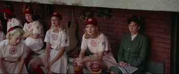 Movie still from “A League of Their Own” (1992), directed by Penny Marshall – A group of women sitting next to each other in a dugout; Medium shot, Low angle