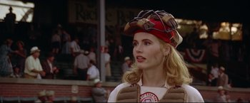 Movie still from “A League of Their Own” (1992), directed by Penny Marshall – A woman in a baseball uniform with a catcher's helmet on her head; Close Up shot, Low angle