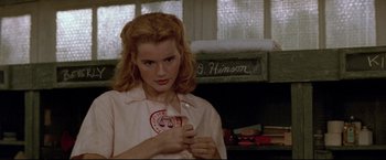 Movie still from “A League of Their Own” (1992), directed by Penny Marshall – A woman in a white shirt is holding a red object; Close Up shot, Low angle