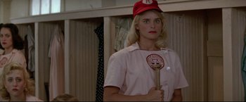 Movie still from “A League of Their Own” (1992), directed by Penny Marshall – A woman holding a baseball bat in a room; Close Up shot, Over the shoulder angle