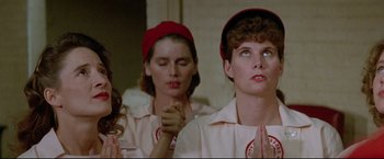 Movie still from “A League of Their Own” (1992), directed by Penny Marshall – A group of women sitting next to each other in a room; Close Up shot, Low angle