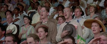Movie still from “A League of Their Own” (1992), directed by Penny Marshall – A group of men and women are singing together; Medium shot, Low angle