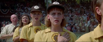 Movie still from “A League of Their Own” (1992), directed by Penny Marshall – Two women in baseball uniforms standing next to each other in front of a crowd; Close Up shot, Low angle