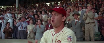 Movie still from “A League of Their Own” (1992), directed by Penny Marshall – A man in a baseball uniform and a red hat is in front of a crowd; Medium shot, Low angle