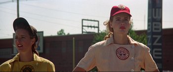 Movie still from “A League of Their Own” (1992), directed by Penny Marshall – A woman in a baseball uniform stands next to another woman in a baseball uniform; Medium shot, Low angle