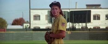 Movie still from “A League of Their Own” (1992), directed by Penny Marshall – A female baseball player in a yellow uniform; Medium shot, Low angle