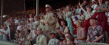 Movie still from “A League of Their Own” (1992), directed by Penny Marshall – A man in a military uniform standing in front of an audience; Medium shot, Low angle