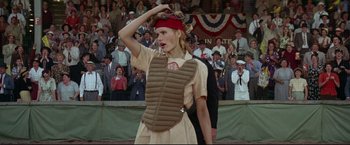 Movie still from “A League of Their Own” (1992), directed by Penny Marshall – A woman wearing a catcher's uniform in front of an audience; Medium shot, Over the shoulder angle