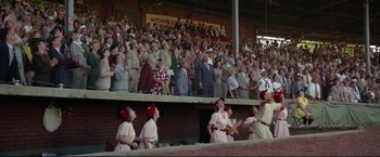 Movie still from “A League of Their Own” (1992), directed by Penny Marshall – A group of people watching a baseball game from the bleachers; Extreme Wide shot, Low angle
