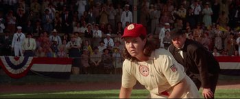 Movie still from “A League of Their Own” (1992), directed by Penny Marshall – A female baseball player in a red hat and uniform; Medium shot, Over the shoulder angle