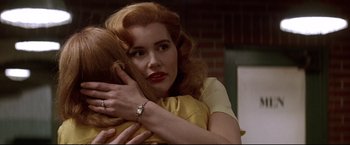 Movie still from “A League of Their Own” (1992), directed by Penny Marshall – A woman is hugging another woman in a yellow dress; Close Up shot, Over the shoulder angle