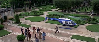 Movie still from “Airport '77” (1977), directed by Jerry Jameson – A group of people walking down a path towards a helicopter; Extreme Wide shot, High angle