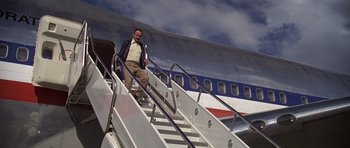 Movie still from “Airport '77” (1977), directed by Jerry Jameson – A man walking down the stairs of an airplane; Wide shot, High angle