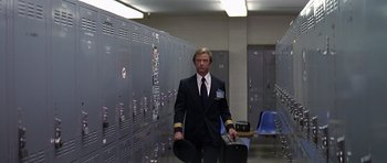 Movie still from “Airport '77” (1977), directed by Jerry Jameson – A man in a suit and tie holding a suit case; Wide shot, Low angle