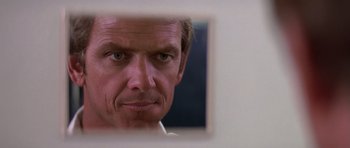 Movie still from “Airport '77” (1977), directed by Jerry Jameson – A person looking at a mirror; Close Up shot, Low angle