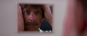 Movie still from “Airport '77” (1977), directed by Jerry Jameson – A person looking at a mirror; Close Up shot, Low angle