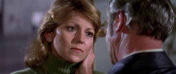 Movie still from “Airport '77” (1977), directed by Jerry Jameson – A person with their hand on her neck; Close Up shot, Over the shoulder angle