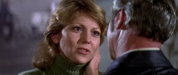 Movie still from “Airport '77” (1977), directed by Jerry Jameson – A person with her hand on her head; Close Up shot, Over the shoulder angle