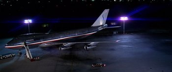 Movie still from “Airport '77” (1977), directed by Jerry Jameson – An airplane on the tarmac at night with lights on; Extreme Wide shot, Overhead angle