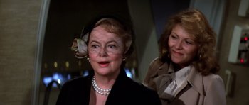 Movie still from “Airport '77” (1977), directed by Jerry Jameson – A woman wearing a hat and a veil; Close Up shot, Over the shoulder angle