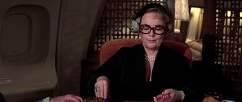 Movie still from “Airport '77” (1977), directed by Jerry Jameson – An older woman sitting at a table playing a card game; Close Up shot, Over the shoulder angle