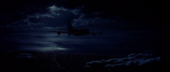 Movie still from “Airport '77” (1977), directed by Jerry Jameson – An airplane is flying in the night sky; Extreme Wide shot, Low angle