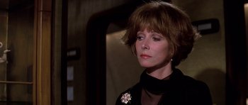 Movie still from “Airport '77” (1977), directed by Jerry Jameson – A person wearing a suit and tie; Close Up shot, Over the shoulder angle