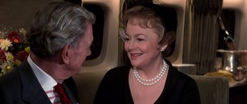 Movie still from “Airport '77” (1977), directed by Jerry Jameson – An older man and a woman talking on a plane; Close Up shot, Over the shoulder angle
